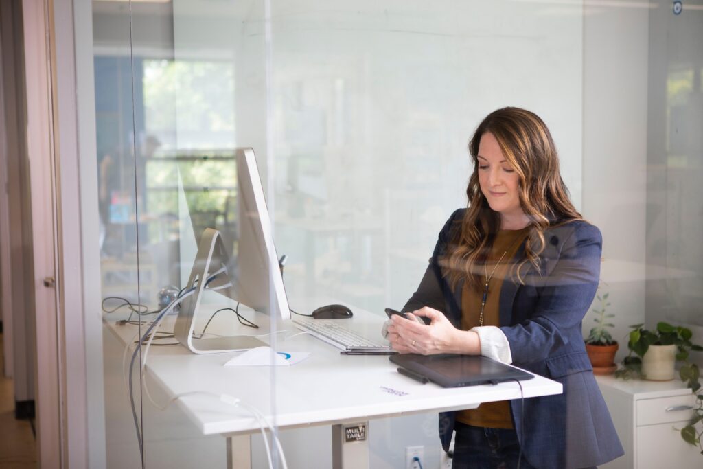 Business Owner using Phone at Computer searching for Same Day Printing in Las Vegas and finding the best choice: Design One Printing