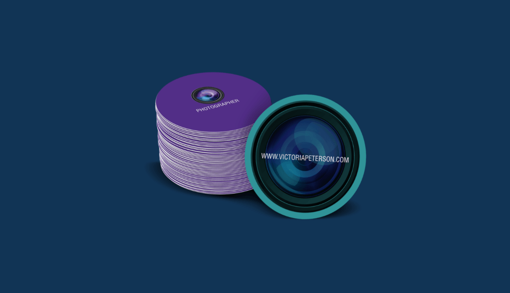 Stack of purple stickers featuring a camera lens graphic and the text "PHOTOGRAPHER" and "www.victoriapeterson.com," emphasizing branding and marketing potential of stickers for businesses.